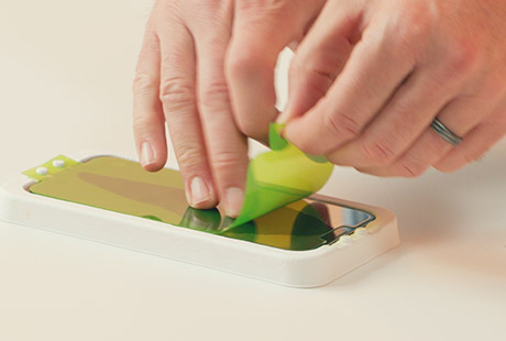 Person using our installation kit to install a new screen protector to her phone with ease.